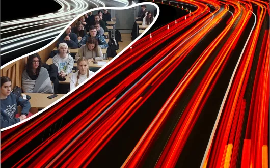 Uczniowie siedzący w ławkach, wokół czerwone i białe krzywe. 