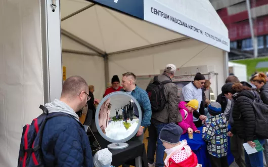 Namiot Centrum Nauczania Matematyki i Fizyki. W środku ludzie. 